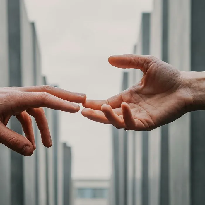 Two hands reaching towards each other